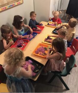 Little Laurelhurst Preschool - Group Photo - Students Playing with Sandboxes at able